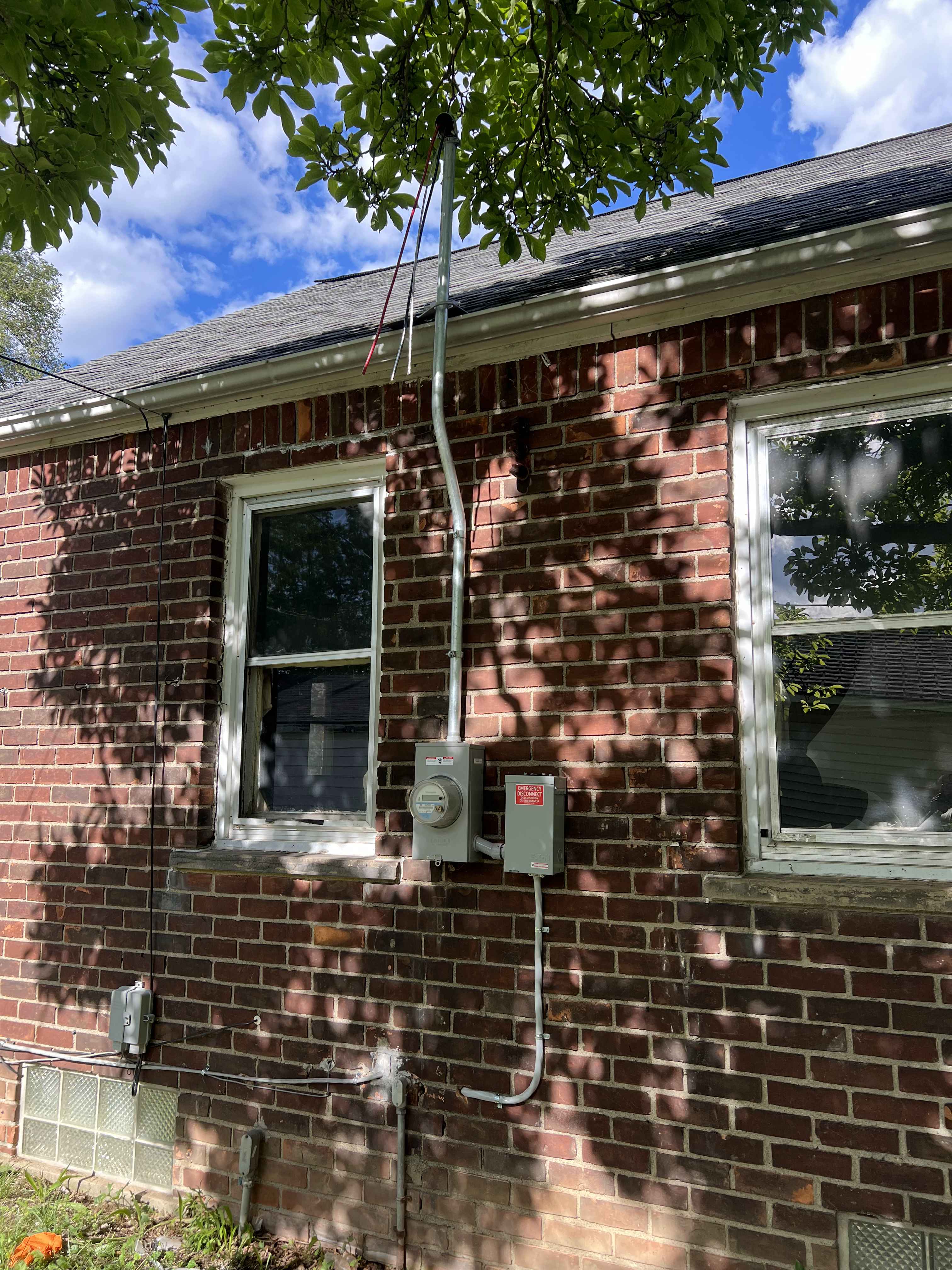Overhead Service Mast & Meter Enclosure — Service mast riser, meter socket, and exterior emergency disconnect